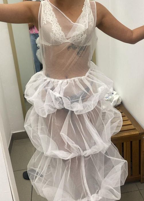Vestido blanco de tul transparente con escote de encaje y falda de volantes en tres alturas, en la prueba